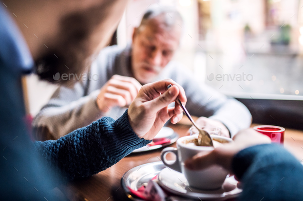 Senior father and his young son in a cafe. Stock Photo by halfpoint