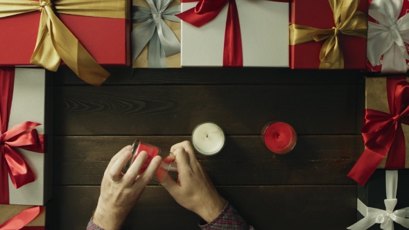 Adult Man Lights Christmas Candles By Decorated Table, Top Down Shot