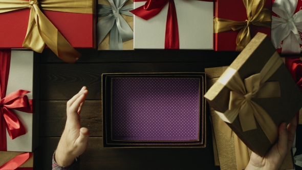 Dissapointed Man Opens Empty Christmas Present Box By Wooden Holiday Table, Top Down Shot