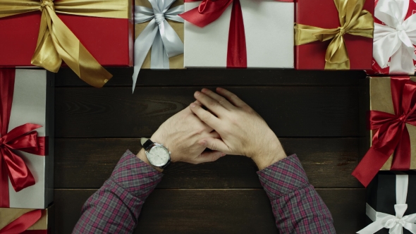 Adult Man with Watch on Hand Sitting By Holiday New Year Wooden Table, Top Down Shot