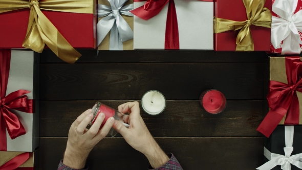 Adult Man Lights Xmas Candles By Decorated Table, Top Down Shot