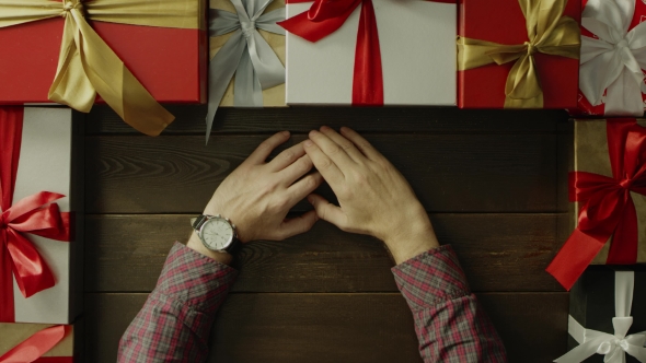 Adult Man with Watch on Hand Sitting By Holiday Wooden Table, Top Down Shot