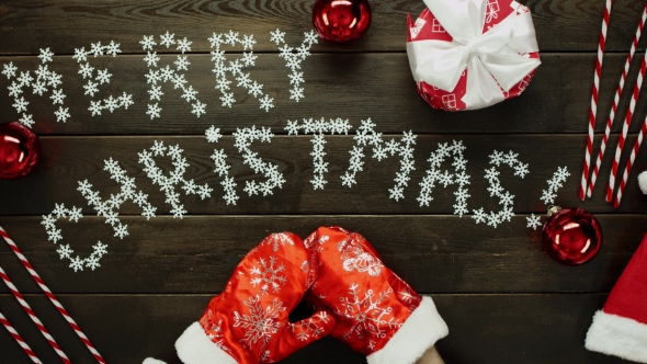 Santa Claus Puts on His Gloves By Wooden Decorated Xmas Table, Top Down Shot