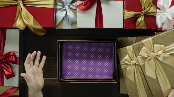 Dissapointed Man Opens Empty Xmas Present Box By Wooden Holiday Table, Top Down Shot