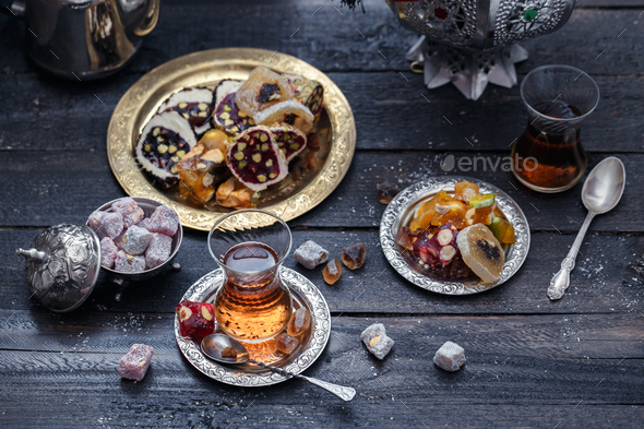 Cup of Turkish tea on saucer on rustic wood with snow in front of a dark blurred background - Stock Photo - Images