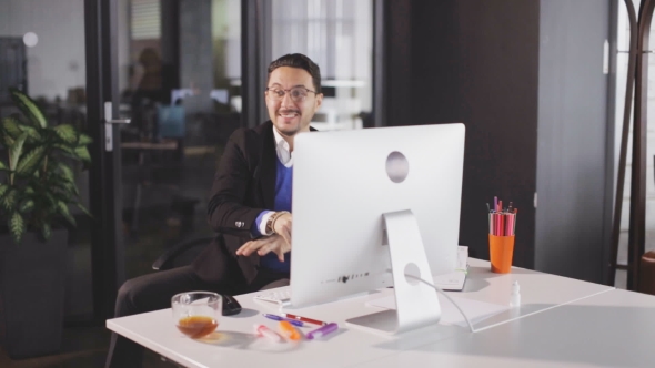 Successful Businessman Juming and Raising Hands in the Office