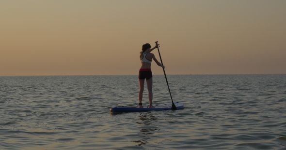 Athletic Girl Rowing on Standup Paddle Board