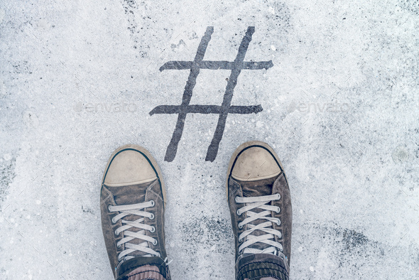 Feet standing over hashtag imprint on street - Stock Photo - Images