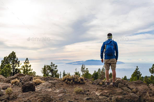 Man celebrating sunset looking at view in mountains - Stock Photo - Images