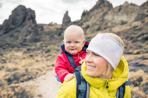 Happy mother with little boy travelling in backpack - Stock Photo - Images