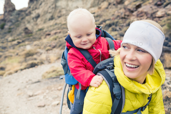Happy mother with little boy travelling in backpack - Stock Photo - Images