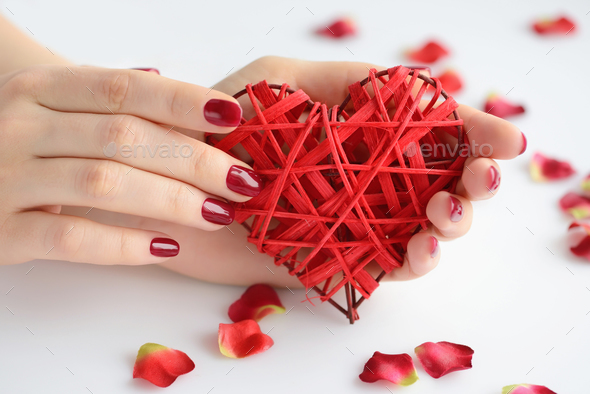 Wicker red heart in woman's hands on white background. Closeup h - Stock Photo - Images