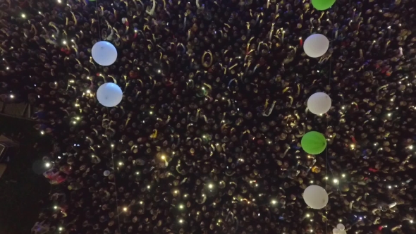 Many People With Lanterns in Their Hands Dance at a Concert