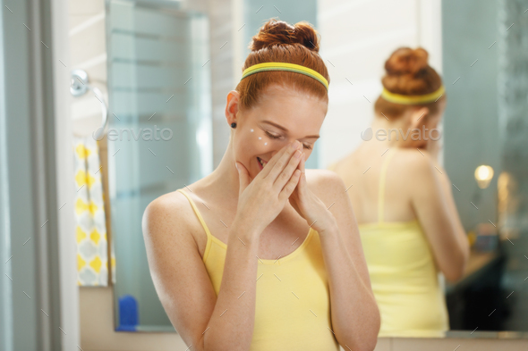 Young Woman Applies Anti Age Cream On Face Smiling - Stock Photo - Images
