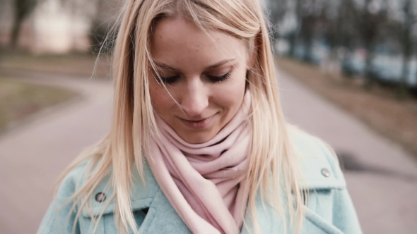 Happy Caucasian Girl Using Smartphone. Cute Young 20s Blonde with Long Hair Messaging Walking. Tilt alt