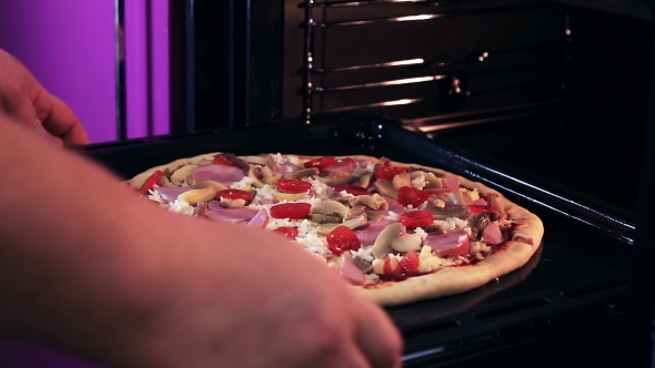 Hand Moves the Tray of Pizza with Mushrooms, Ham and Mozzarella Cooked Baking
