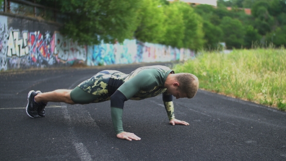 Young Attractive Sportsman Doing Push-ups on the Ground Outdoor Stadium
