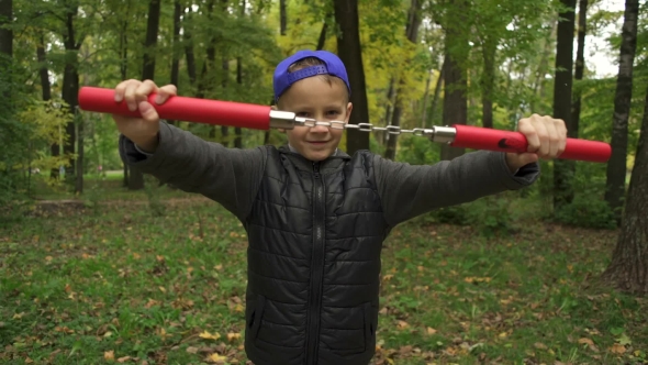 A Boy of 8-10 Years Shows His Ability to Fight Nunchaku
