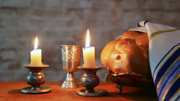 Shabbat Candles in Glass Candlesticks with Blurred Covered Challah alt