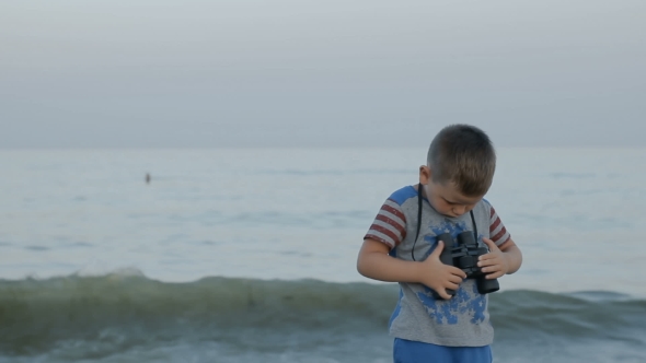 Boy in American T-shirt Looks Through Binoculars