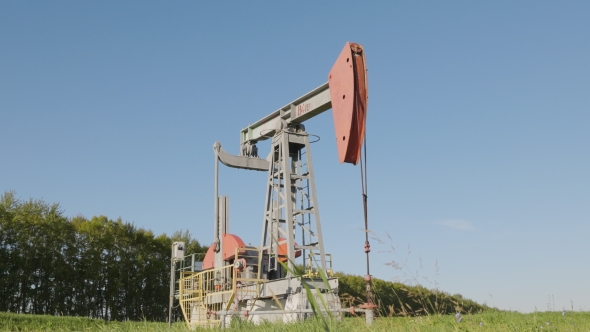 Operating Oil and Gas Well in Oil Field, Profiled Against the Blue Sky