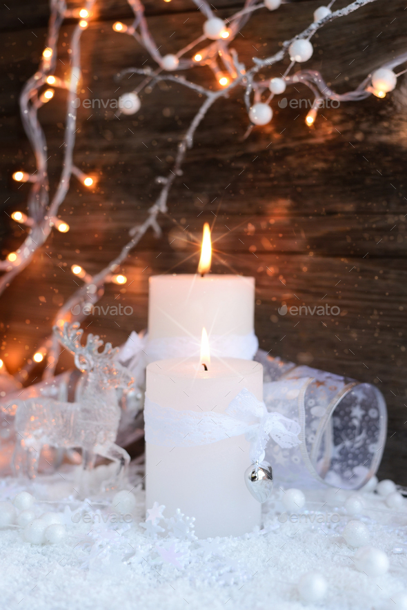 Two burning candles with a deer with christmas decorative balls - Stock Photo - Images