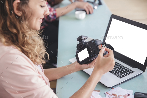 young female photographer inserting the memory card to the camer Stock Photo by odua