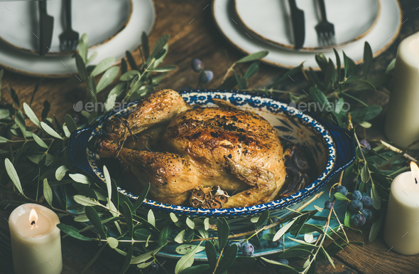 Whole roasted chicken with garlic decorated with olive tree branch - Stock Photo - Images