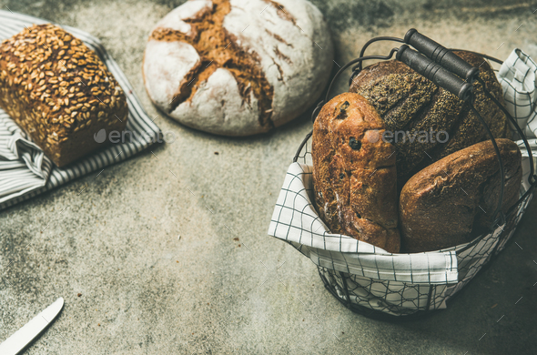Various bread loaves on grey concrete background, copy space - Stock Photo - Images