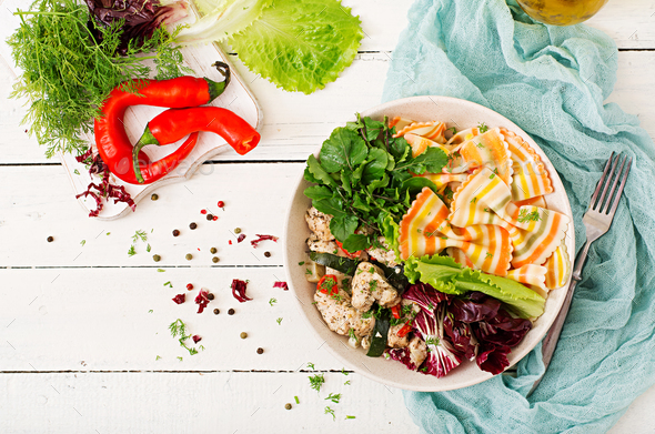 Farfalle pasta durum wheat with baked chicken fillet with eggplant, zucchini and salad in bowl - Stock Photo - Images