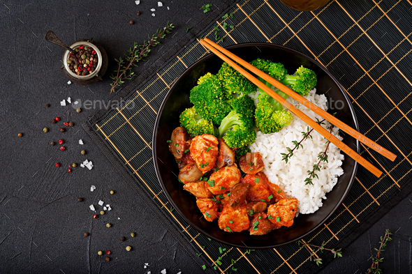 Pieces of chicken fillet with mushrooms stewed in tomato sauce with boiled broccoli and rice - Stock Photo - Images