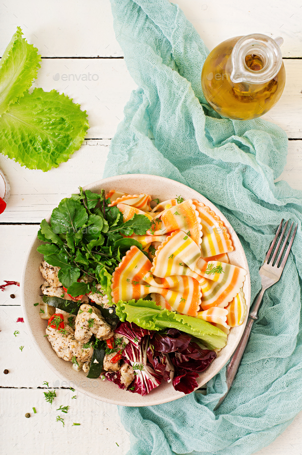 Farfalle pasta durum wheat with baked chicken fillet with eggplant, zucchini and salad in bowl. - Stock Photo - Images