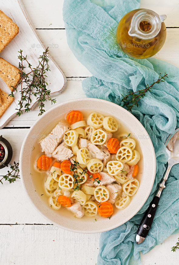 Dietary soup with turkey or chicken fillet with pasta Ruote and herbs. Flat lay. Top view Stock Photo by Timolina