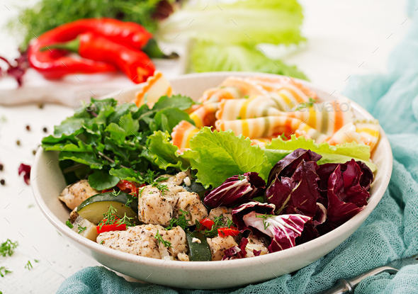 Farfalle pasta durum wheat with baked chicken fillet with eggplant, zucchini and salad in bowl. - Stock Photo - Images