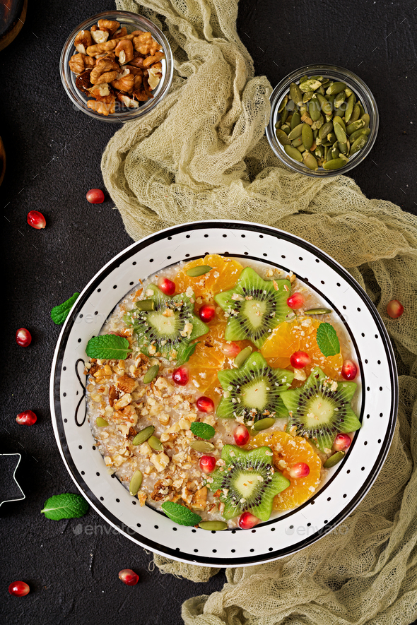 Tasty and healthy oatmeal porridge with fruit, berry and nuts. - Stock Photo - Images