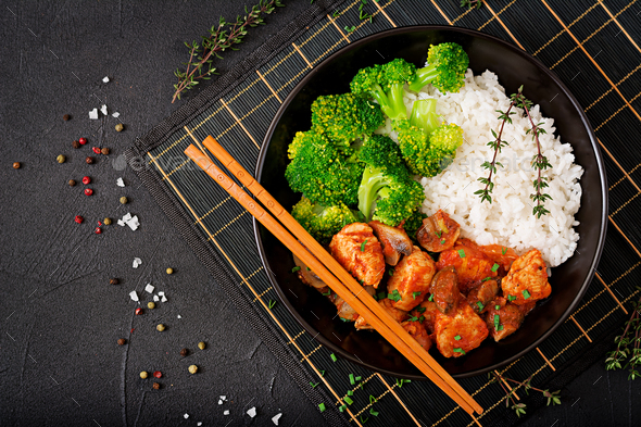 Pieces of chicken fillet with mushrooms stewed in tomato sauce with boiled broccoli and rice. - Stock Photo - Images