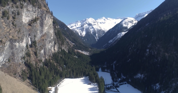 Descent of the Drone in the Winter Mountain Valley in Austria