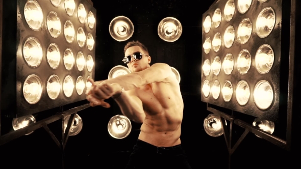 Sexy Man Dancing on the Background of Lights