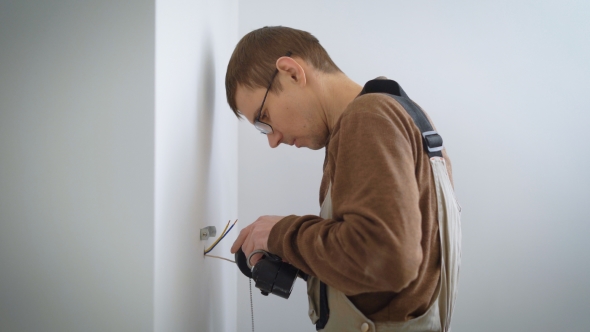 Electrician Is Connecting Wires To Wall Lamp for Installing on a New Walls in a Refurbished alt