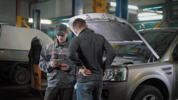 Client and Car Mechanic Standing Near Car alt