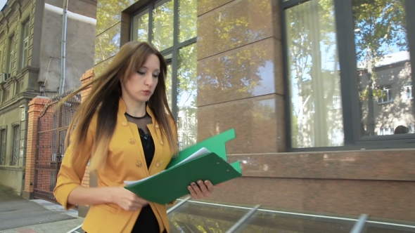 Business Lady in Yellow Jacket Is Angry and Throws Financial Documents Out of Green Folder alt