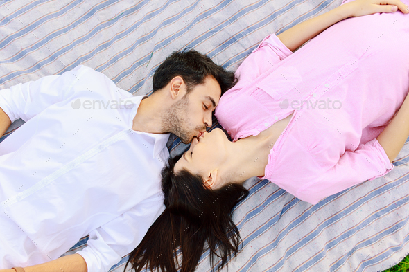 Enjoying closeness top view of beautiful young loving couple lying together. - Stock Photo - Images