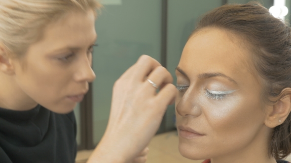 Professional Make-up Artist Glues Artificial Eyelashes of the Model. Preparation for an Artistic