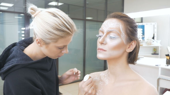 Professional Make-up Artist Draws Body Art on the Model. Preparing for a Photo Session alt