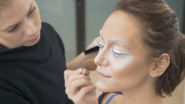 A Professional Make-up Artist Does the Make-up of the Model. Apply a Special Brush with a Tonal