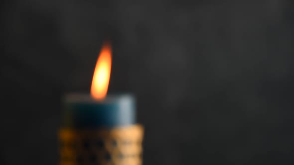 Blue candle trembling flame with grey background focusing in and blown out alt
