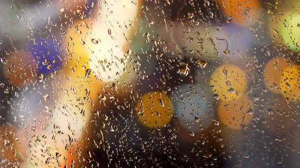 Water Drop on Window Glass with Blurred Lights on Background