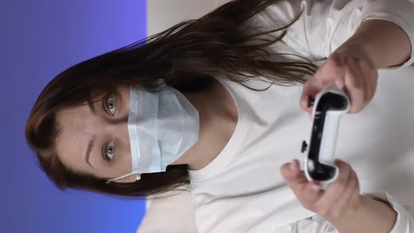 Vertical Shot Attractive Girl Having Fun During Quarantine Plays Games with Joystick at Home