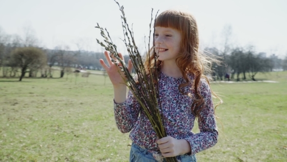 Happy Ginger Girl in the Park with a Spring Bunch of Branches