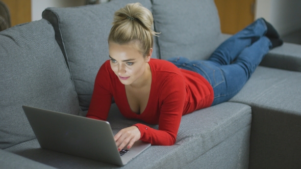 Attractive Woman Using Laptop on Sofa alt